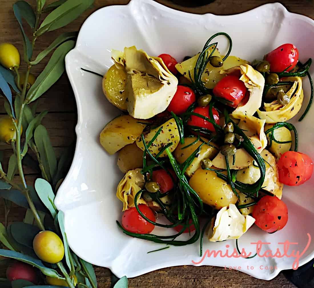 Hot salad with potatoes, artichokes and savory greens